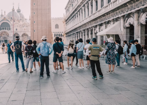 Tourists standing in a historic plaza with columned buildings
